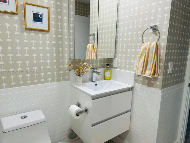 a bathroom with a sink a toilet and a mirror