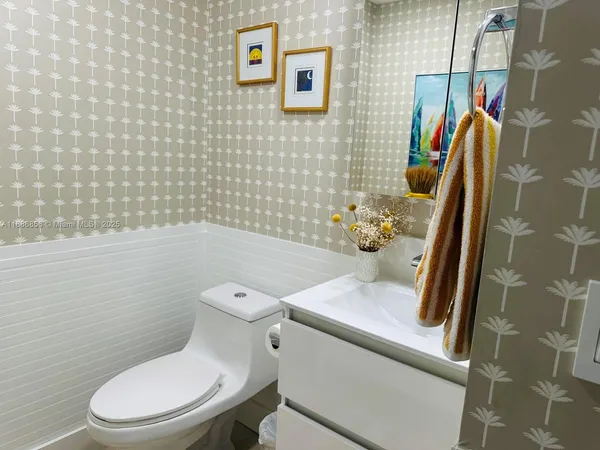 a white toilet sitting next to a bathroom sink