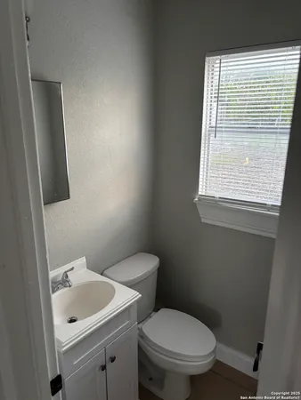 a bathroom with a toilet sink and mirror