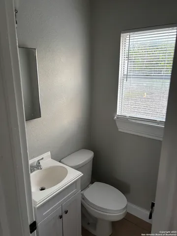 a bathroom with a toilet sink and mirror