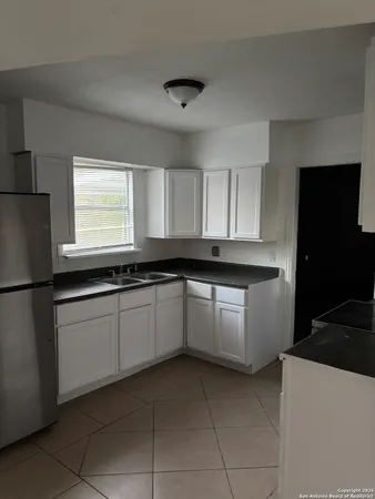 a kitchen with a refrigerator sink and cabinets