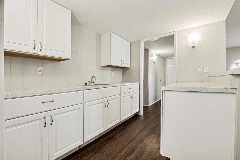 6532 Blue Ridge Trail Plano, TX 75023 - Photo 12 of 25 a kitchen with granite countertop white cabinets and a sink