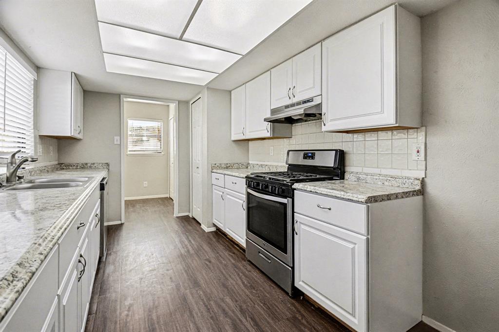 6532 Blue Ridge Trail Plano, TX 75023 - Photo 14 of 25 a kitchen with stainless steel appliances granite countertop a stove a sink and white cabinets