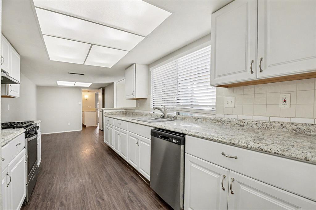 6532 Blue Ridge Trail Plano, TX 75023 - Photo 15 of 25 a kitchen with granite countertop white cabinets and white appliances