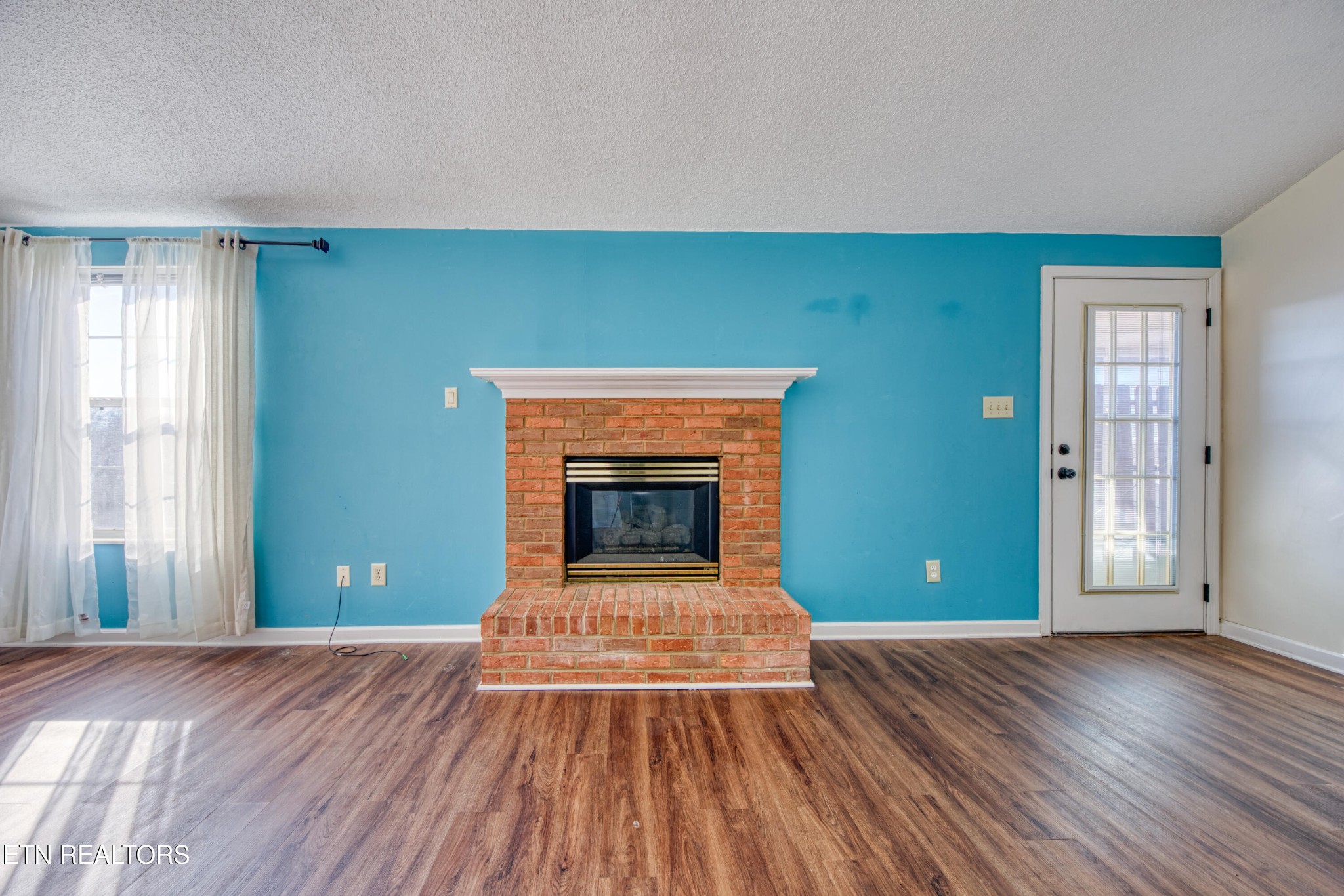 8024 Keybridge Way Powell, TN 37849 - Photo 8 of 23 a view of empty room with wooden floor and fireplace