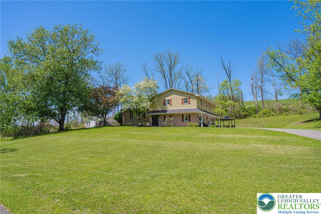 3857 Friedens Road Slatington, PA 18080 - Photo 3 of 75 This classic two-story residence is nestled on a expansive verdant lawn, offering serene outdoor living.