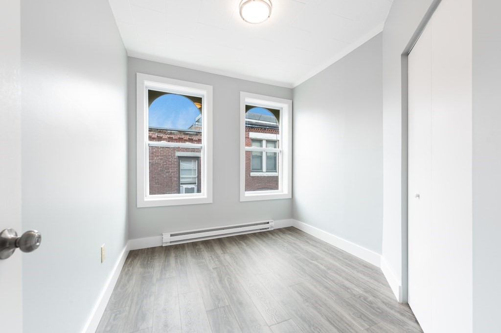 12 Foster Street, Unit 8 Boston, MA 02109 - Photo 6 of 12 an empty room with wooden floor and windows