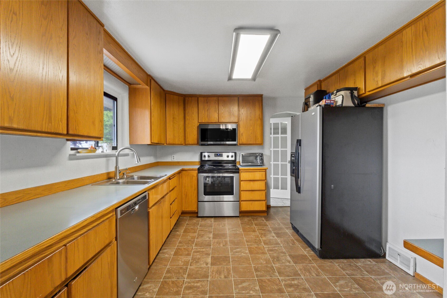 5117 Delaware Avenue Everett, WA 98203 - Photo 10 of 36 a kitchen with stainless steel appliances a stove sink and cabinets