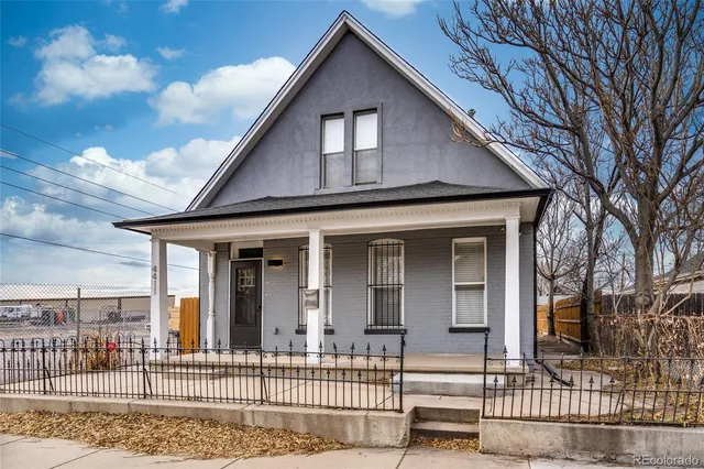 a view of a house with a small yard plants and large tree
