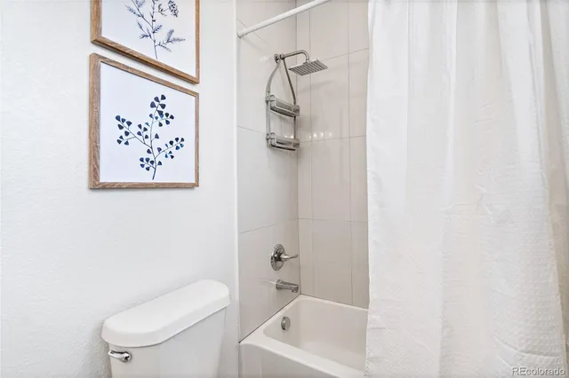 a bathroom with a toilet and a shower curtain