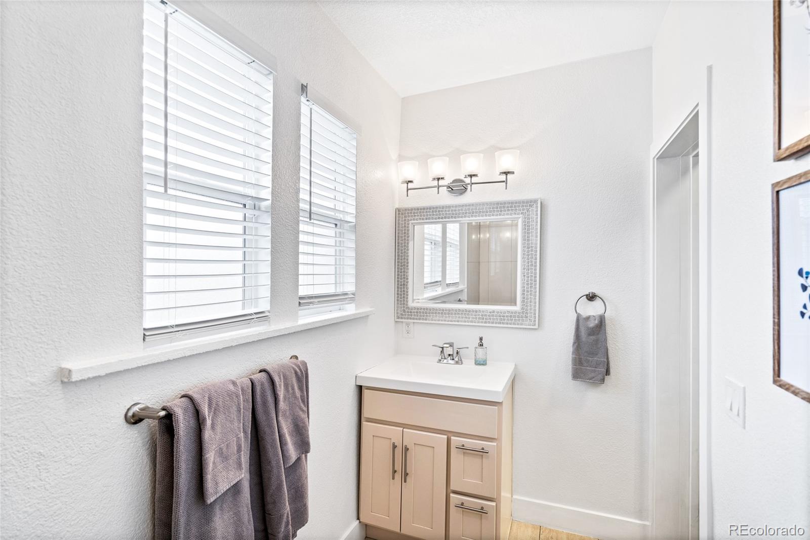 Undisclosed Address Denver, CO 80216 - Photo 20 of 25 a bathroom with a double vanity sink and mirror