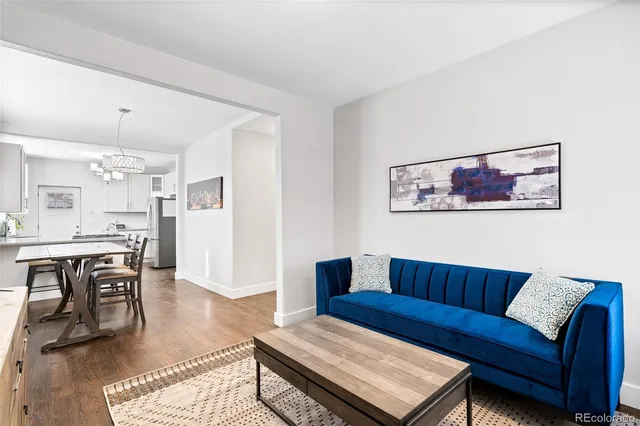 a living room with furniture a refrigerator and kitchen view