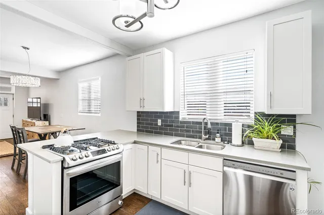 a kitchen with stainless steel appliances granite countertop a sink a stove and a window