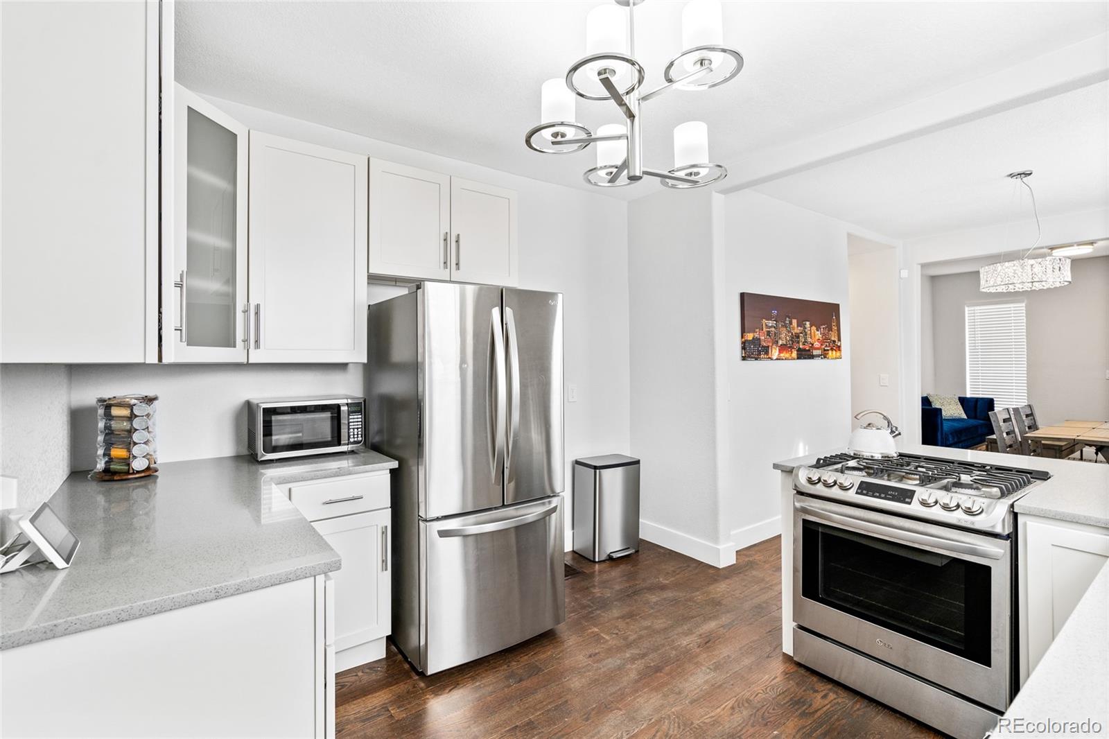 Undisclosed Address Denver, CO 80216 - Photo 8 of 25 a kitchen with stainless steel appliances granite countertop a refrigerator a stove a sink dishwasher and a dining table with wooden floor