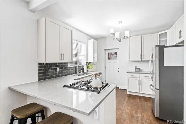 a kitchen with white cabinets and appliances