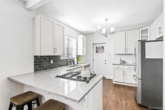 a kitchen with white cabinets and appliances