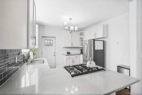 a kitchen with stainless steel appliances a stove a sink and a refrigerator
