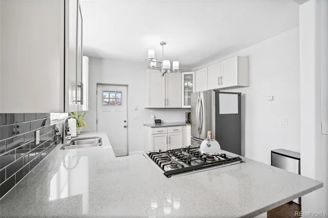 a kitchen with stainless steel appliances a stove a sink and a refrigerator