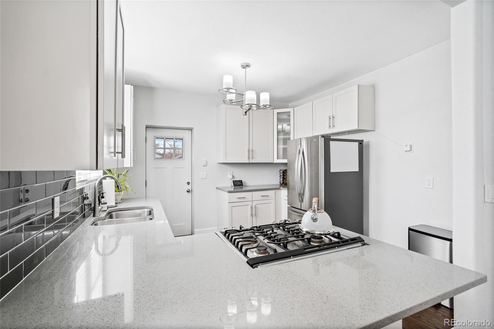 Undisclosed Address Denver, CO 80216 - Photo 10 of 25 a kitchen with stainless steel appliances a stove a sink and a refrigerator