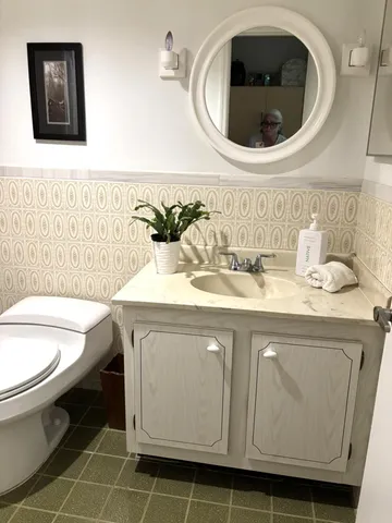 a bathroom with a toilet sink and mirror