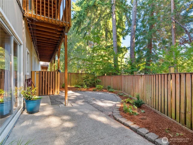 a view of backyard with potted plants and wooden fence