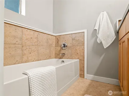 a white bath tub sitting next to a white sink and vanity