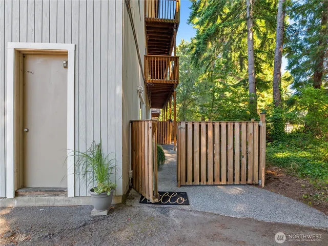 a view of a house with a small yard and a large tree