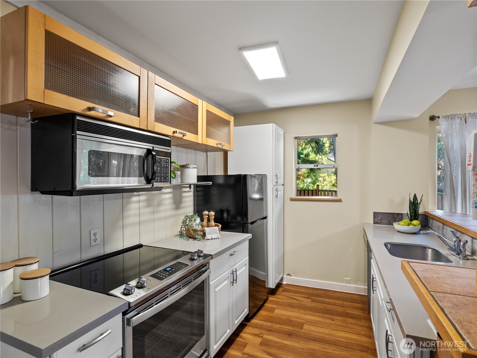 465 Winslow Way East, Unit 108 Bainbridge Island, WA 98110 - Photo 8 of 38 a kitchen with stainless steel appliances a stove a sink and a microwave