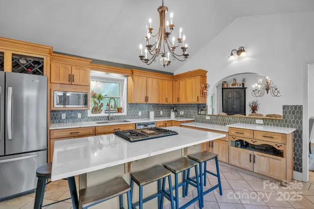 a kitchen with stainless steel appliances a stove a sink dishwasher and cabinets with wooden floor
