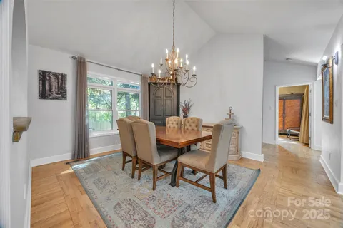 a dining room with furniture a rug and a chandelier