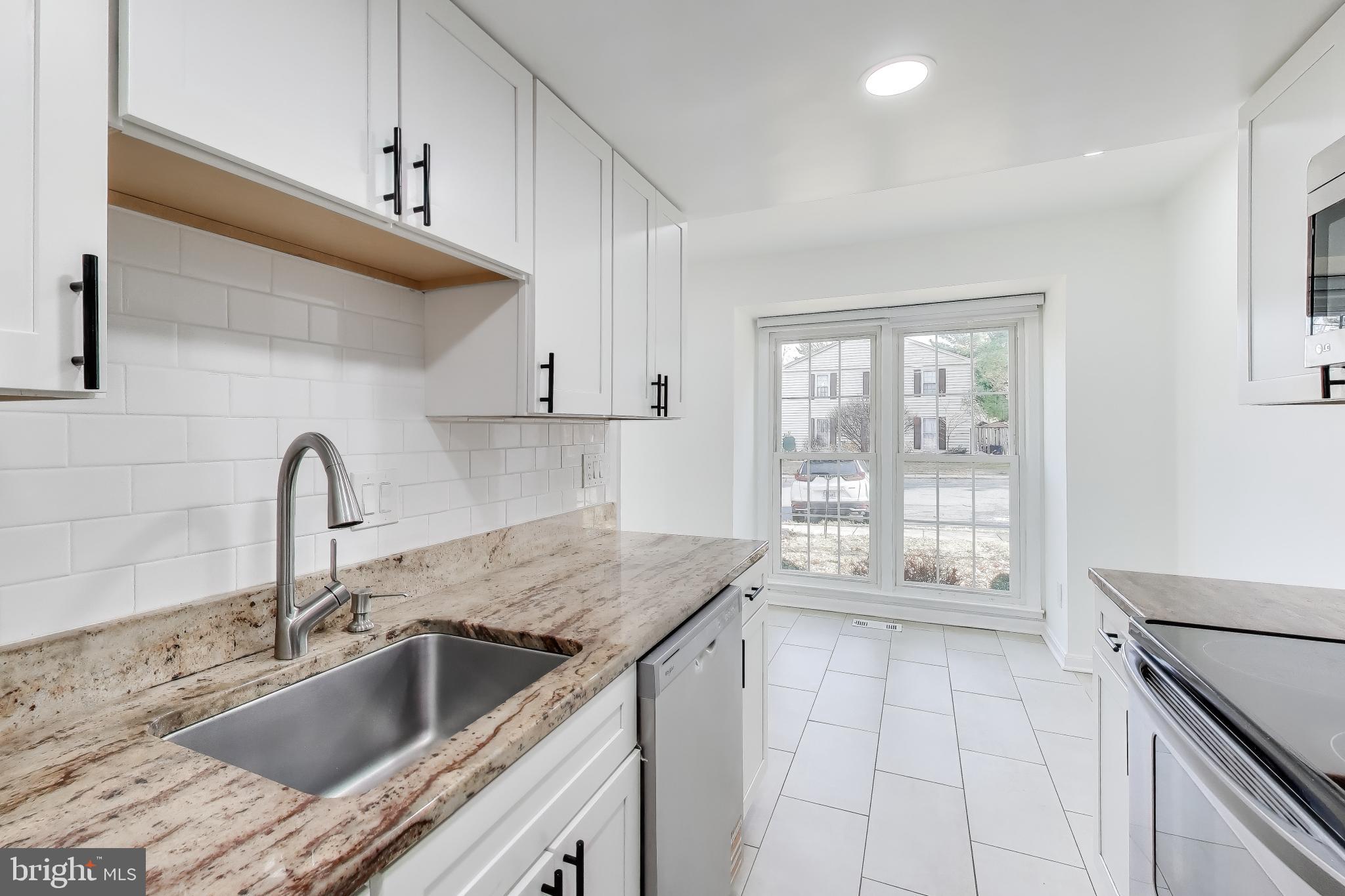 20210 Maple Leaf Court Gaithersburg, MD 20886 - Photo 3 of 31 a kitchen with granite countertop a sink and a stove top oven
