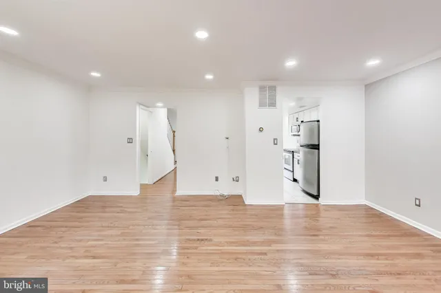 a view of empty room with wooden floor