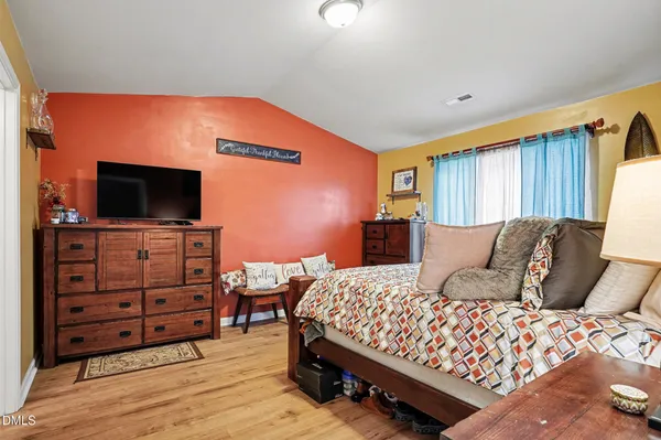 a bedroom with a bed and flat screen tv