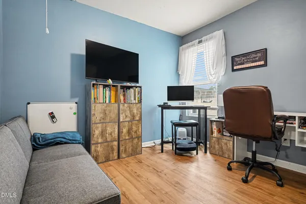 a bedroom with workspace and a window