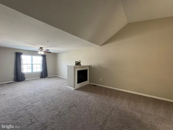 an empty room with a fireplace and windows