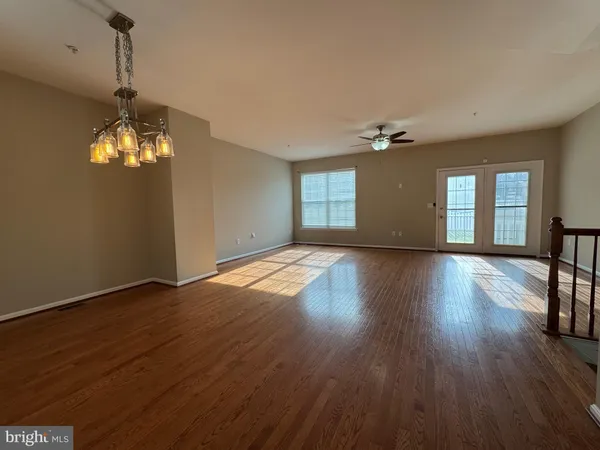 a view of a livingroom with wooden floor and a chandelier