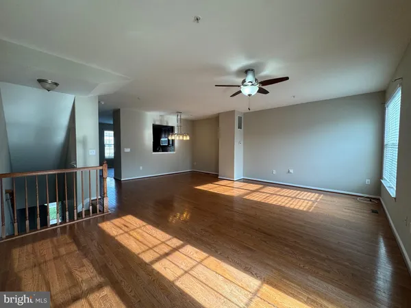 a view of a livingroom with wooden floor and a ceiling fan