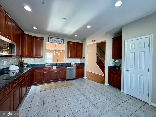 a kitchen with stainless steel appliances granite countertop a refrigerator and a stove top oven
