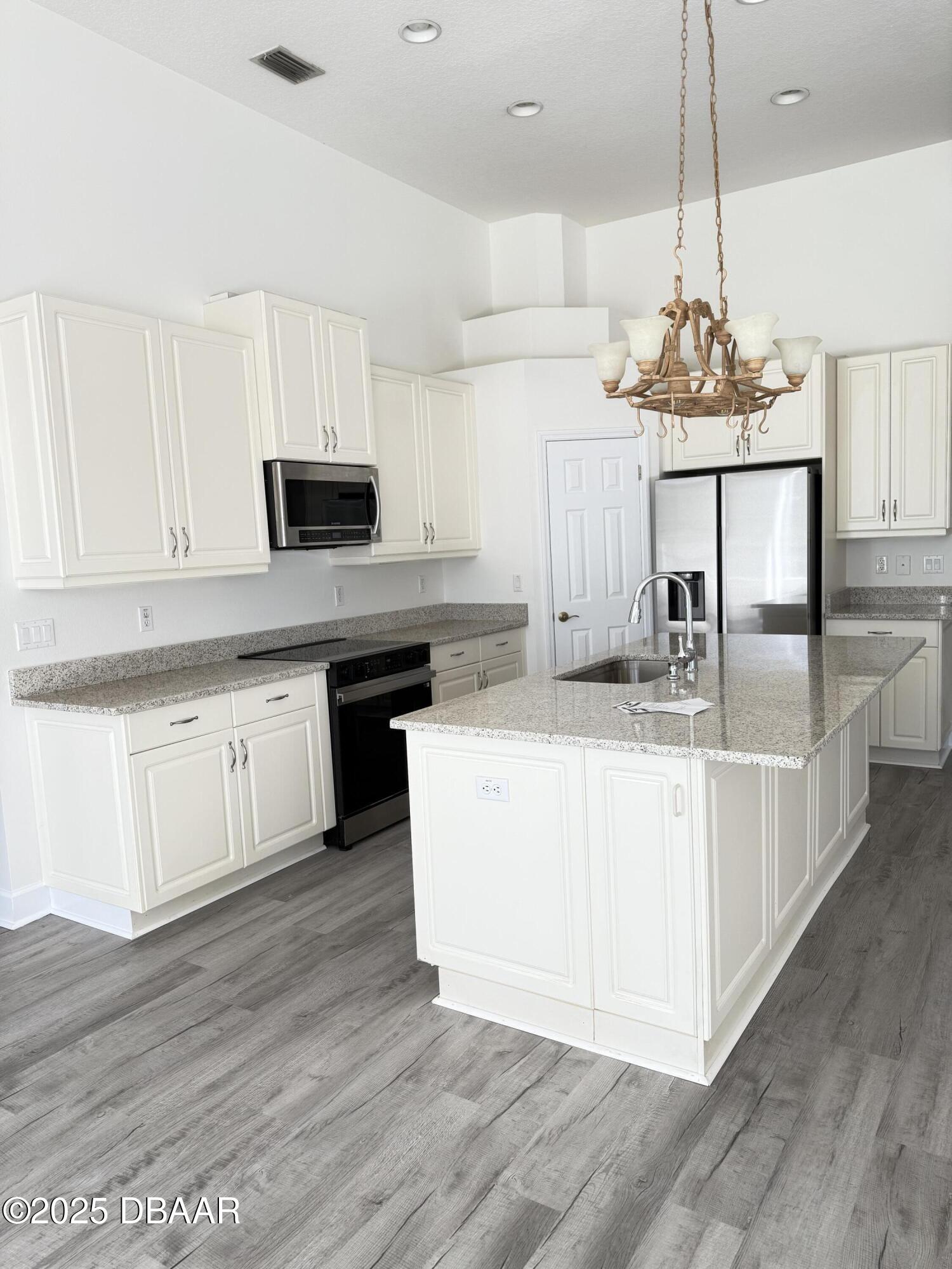 14 Deep Woods Way Ormond Beach, FL 32174 - Photo 20 of 38 a kitchen with kitchen island granite countertop a sink a counter top space and cabinets