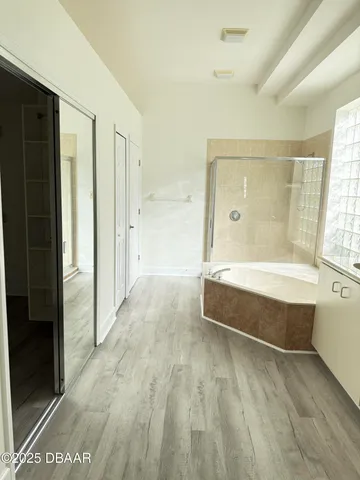 an empty room with wooden floor closet and windows