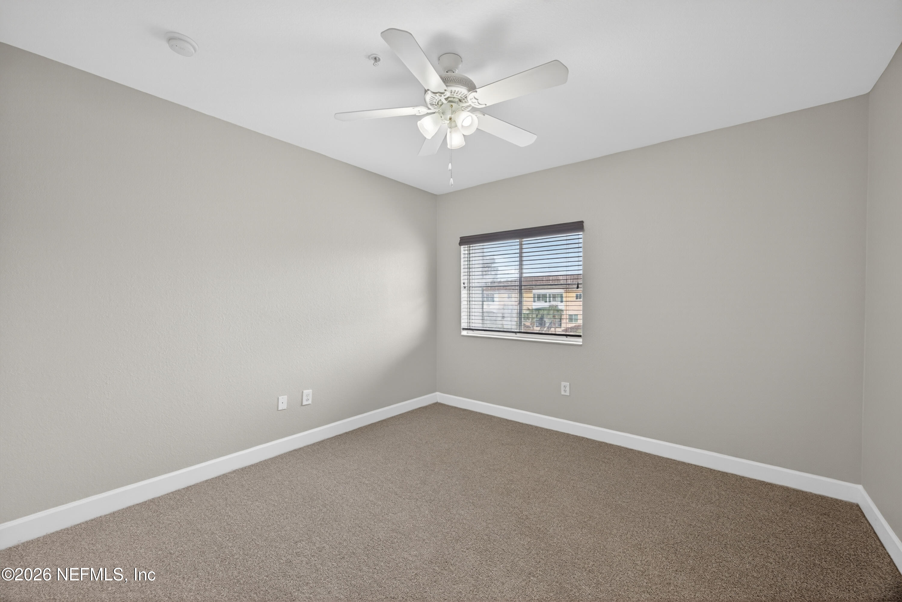 9745 Touchton Road, Unit 1224 Jacksonville, FL 32246 - Photo 11 of 22 an empty room with a chandelier fan and windows