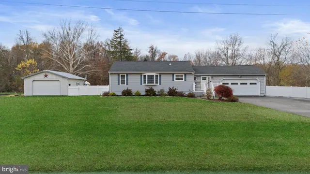 a front view of a house with a garden and trees