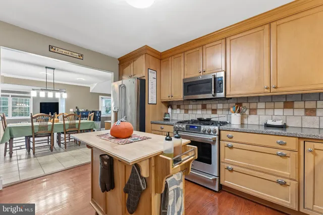 a kitchen with stainless steel appliances a stove a sink and a refrigerator