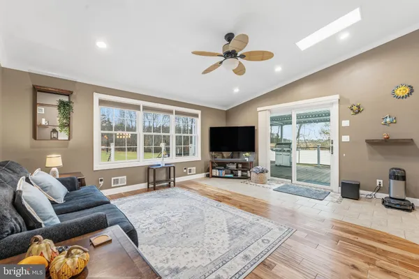 a living room with furniture and a flat screen tv with wooden floor
