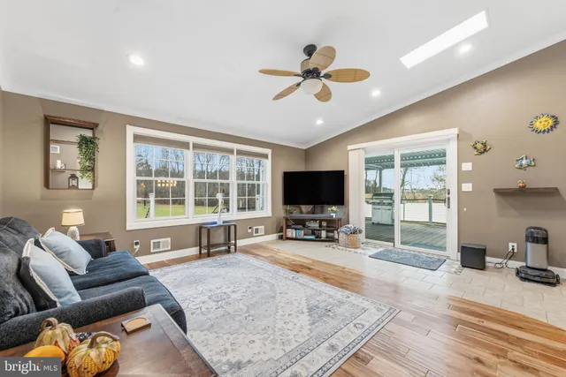 a living room with furniture and a flat screen tv with wooden floor