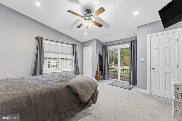 a spacious bedroom with a large bed a flat tv screen and closet