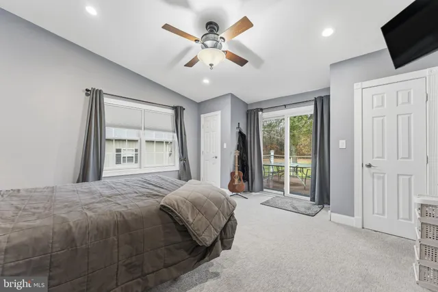 a spacious bedroom with a large bed a flat tv screen and closet