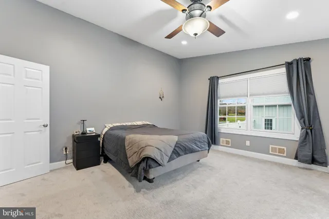 a spacious bedroom with a bed and a large window