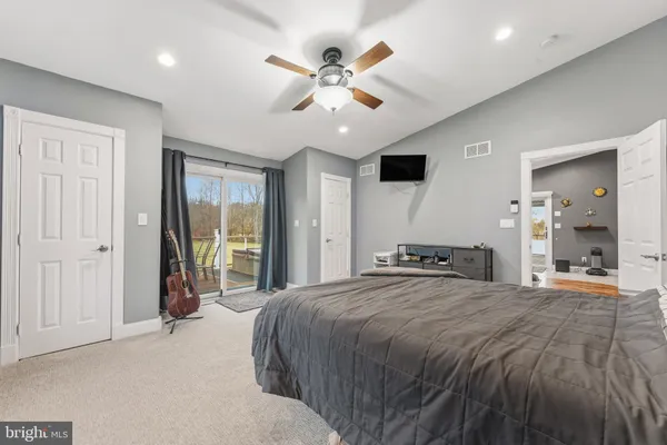 a spacious bedroom with a large bed and a chandelier