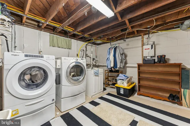 a utility room with dryer washer and a view of living room